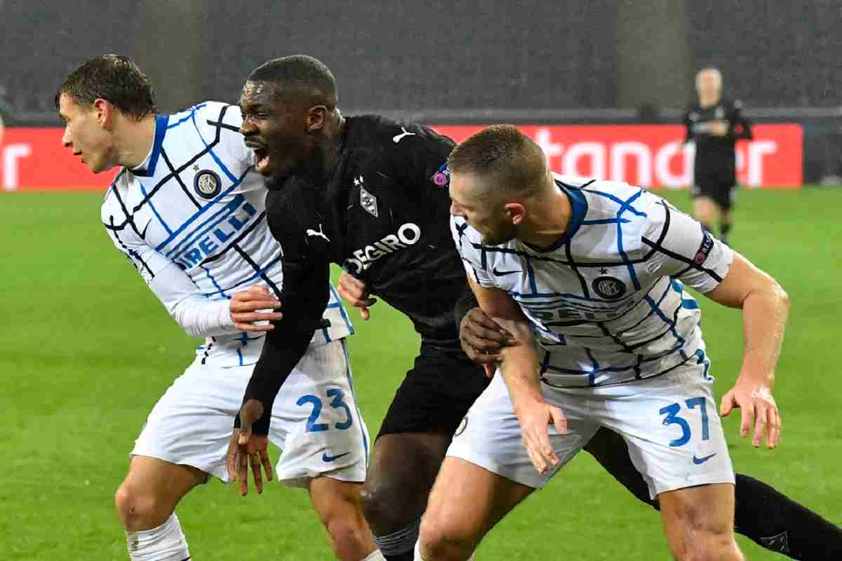 Marcus Thuram stretto tra Milan Skriniar e Nicolò Barella.