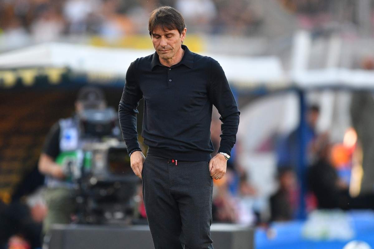 Antonio Conte in piedi, con gli occhi chiusi e le mani in tasca