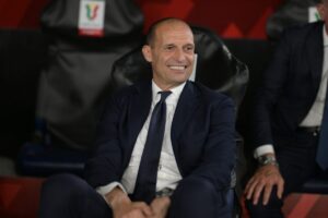 Massimiliano Allegri sorridente e seduto in panchina
