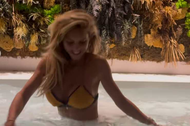 Michela Persico in costume mentre entra in vasca 